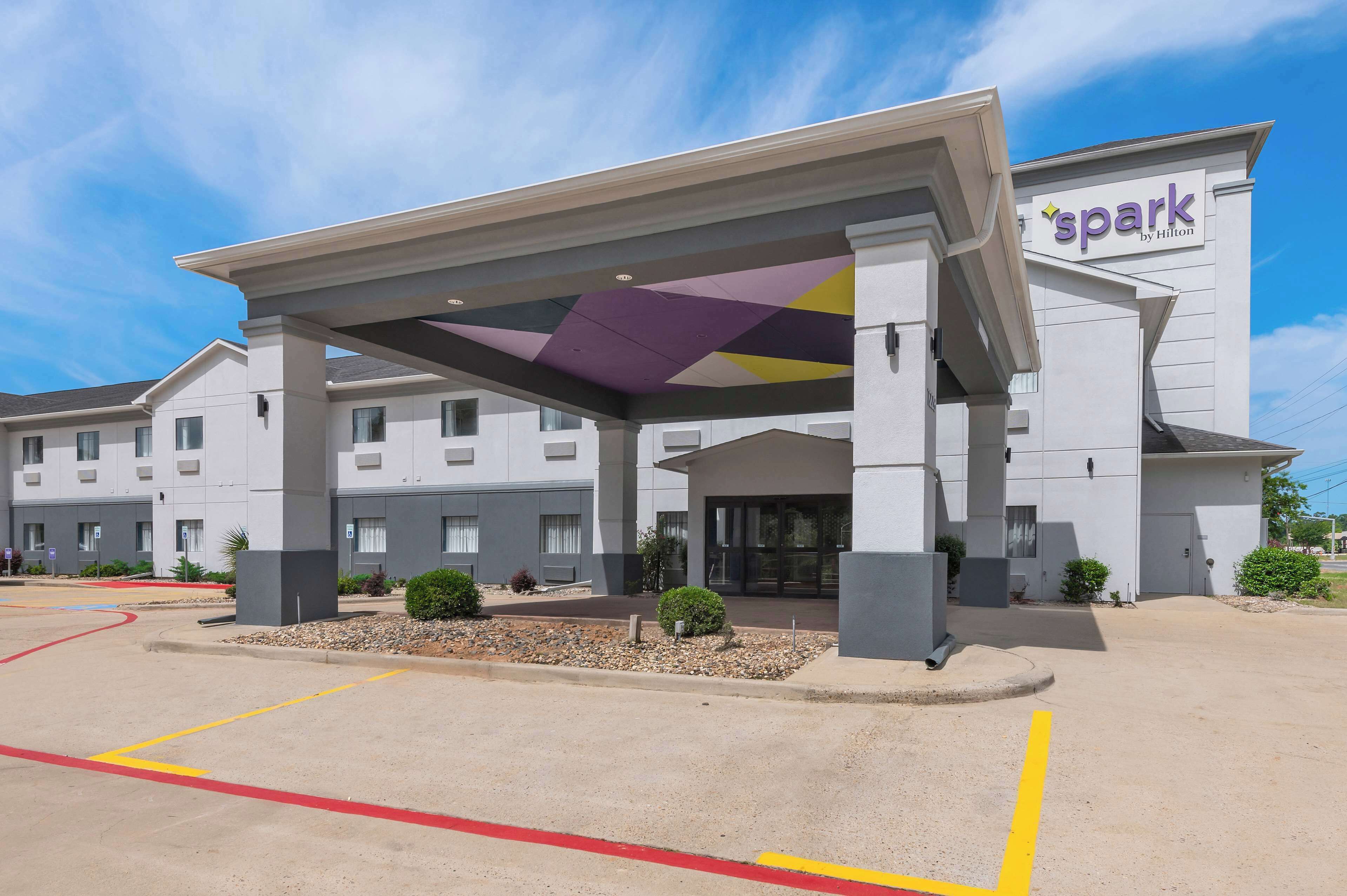 A hotel with a modern design, featuring a covered entrance and a prominent sign.