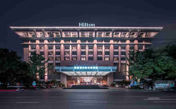 Un hotel Hilton moderno con una entrada destacada y un cartel grande sobre la entrada principal.
