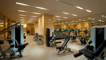 A modern gym with various exercise equipment, a large mirror, and a clean, well-lit interior.