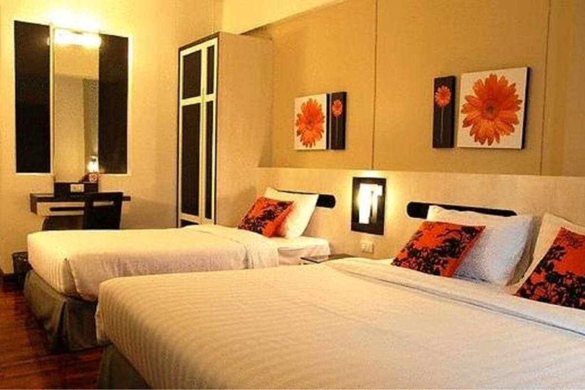 Een hotelkamer met twee bedden, een bureau en een spiegel.