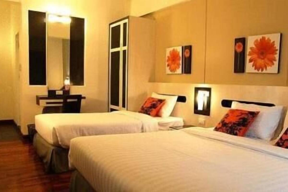 Een hotelkamer met twee bedden, een bureau en een spiegel.
