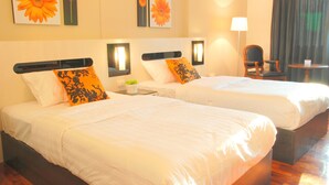 Two single beds with white linens, a nightstand with a lamp, and a chair. - The Inn Saladaeng (Bangkok)
