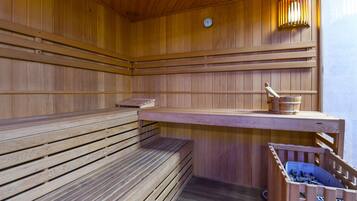 Eine Holzsauna mit Bänken und einem Holztisch.