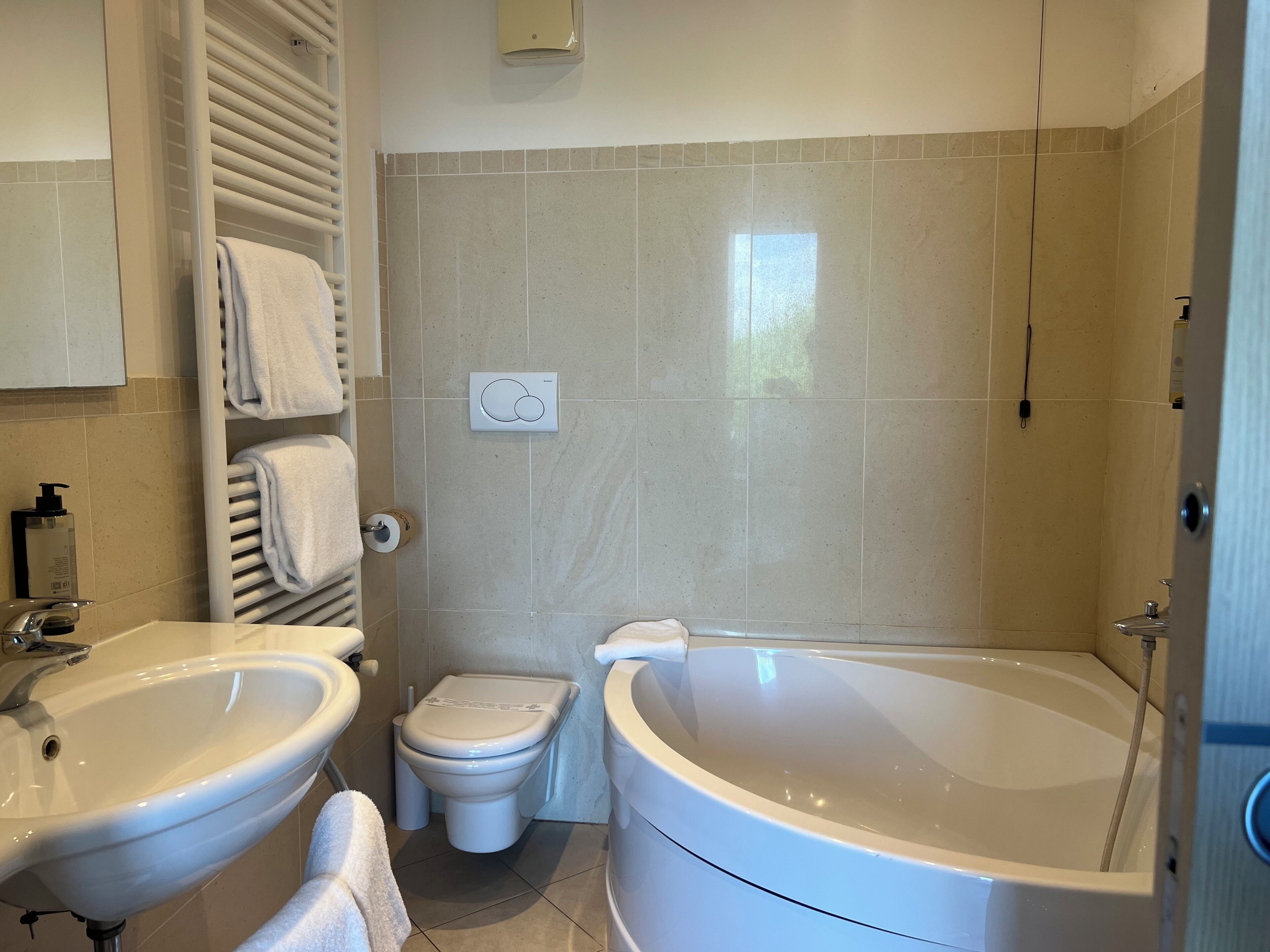 Un baño con dos lavamanos, un inodoro y una bañera.