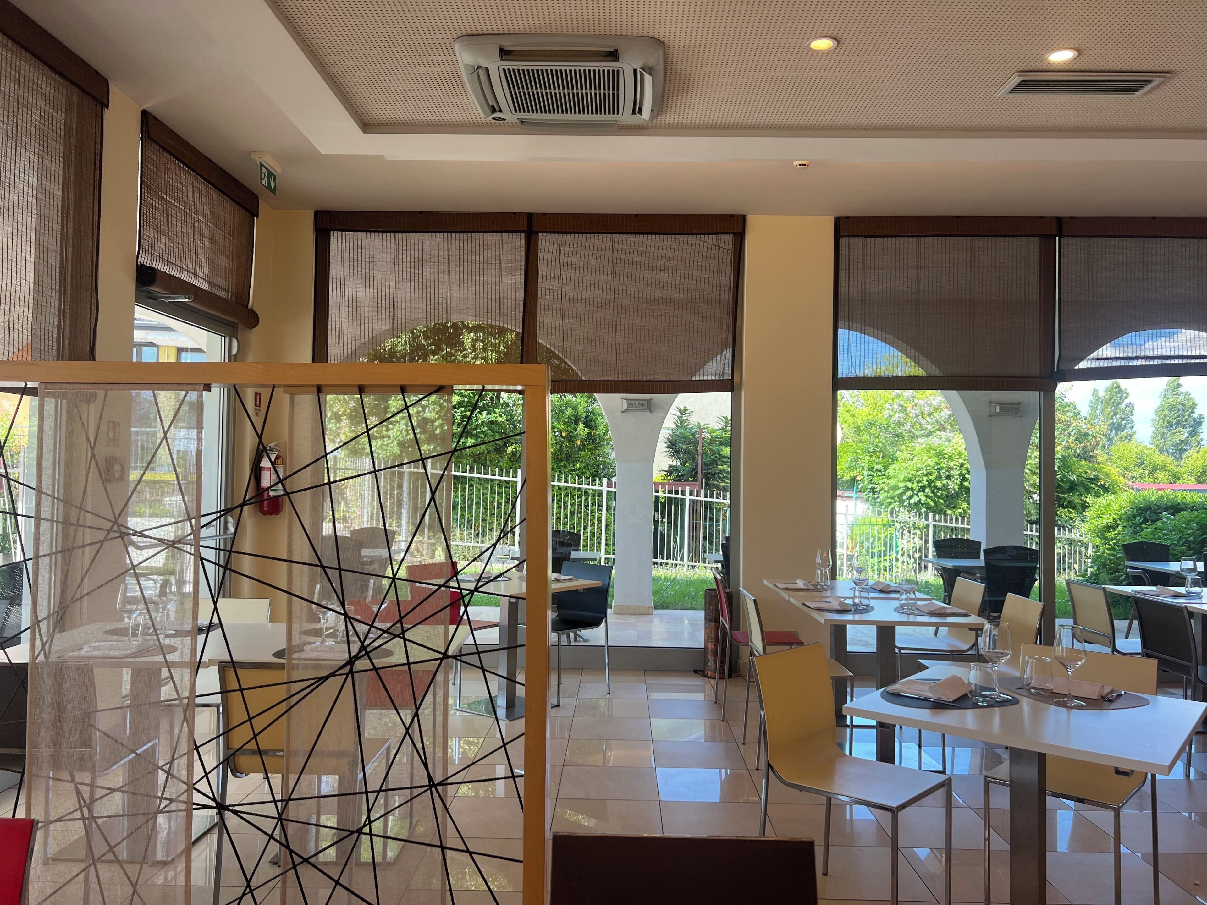 Ein Restaurant mit modernem Interieur, großen Fenstern und Blick ins Freie.