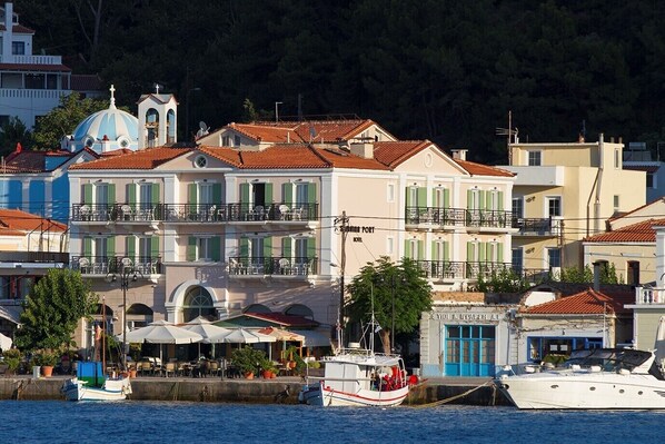 A coastal building with multiple balconies, a blue dome, and a sign for a hotel.