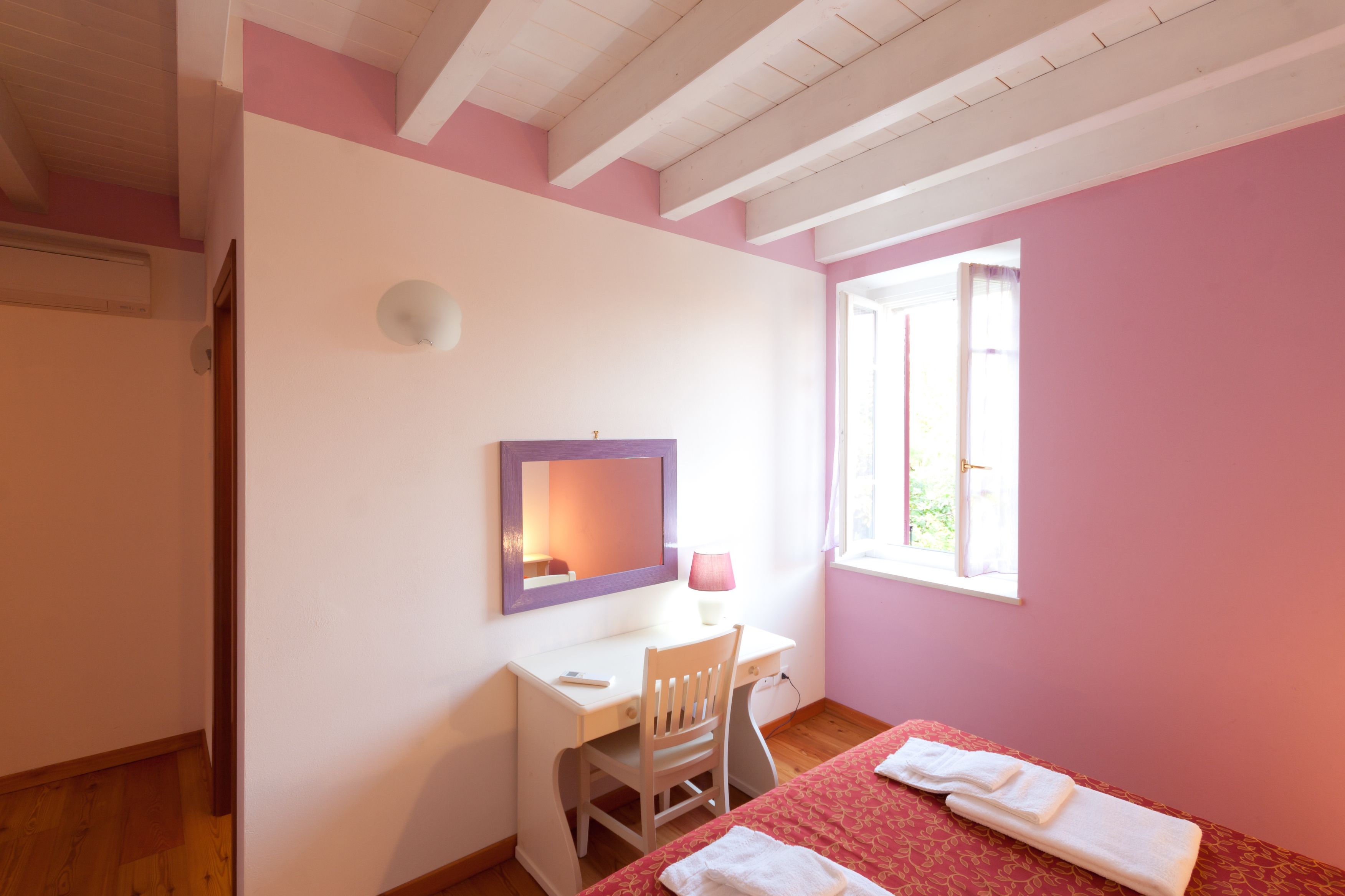 Un dormitorio con una cama, un escritorio y una silla.
