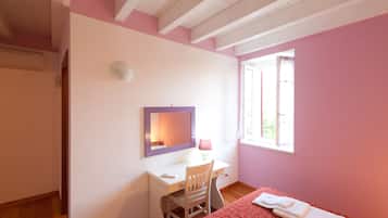 Un dormitorio con una cama, un escritorio y una silla.