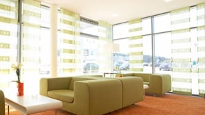 A modern lobby with a green sofa, a white table, and patterned carpet.