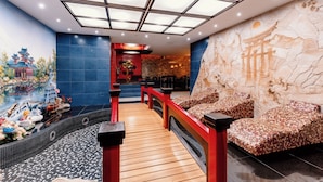 A traditional Chinese-themed spa area with a wooden walkway, red railings, and a mural of a pagoda. - President Hotel (Bacioi)