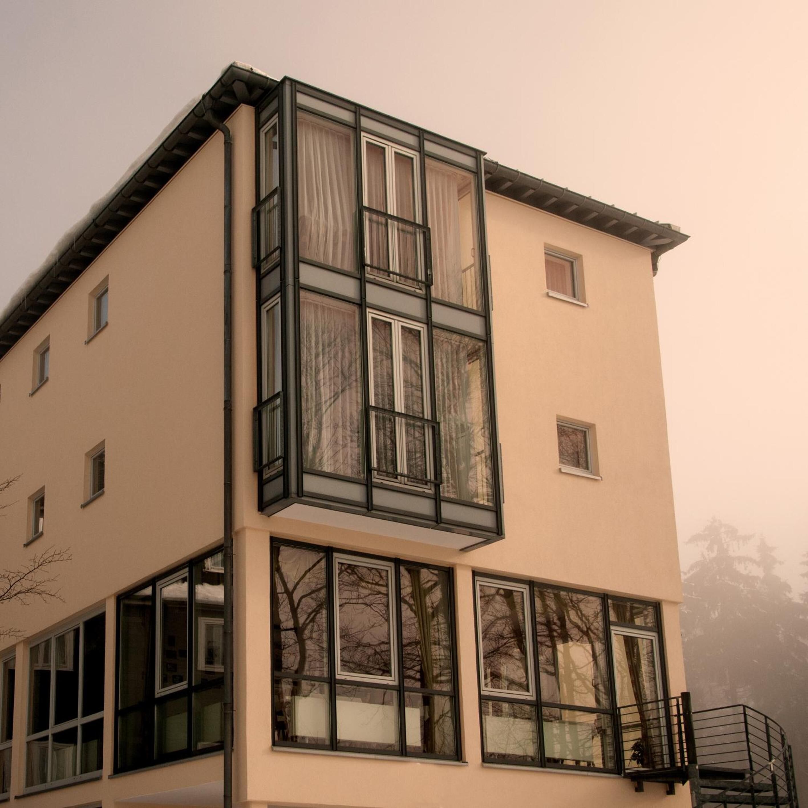 Ein mehrstöckiges Gebäude mit großen Fenstern und einem Balkon.