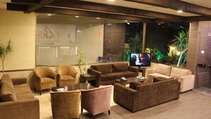 A modern lobby with sofas, a coffee table, and a television. - Bliss 3000 Furnished Studios (Beirut)