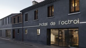 En modern hotellfasad med en skylt som visar texten ”hôtel de l’octroi”.