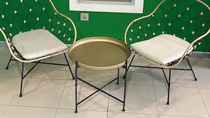 Two wicker chairs with cushions, a small round table, and a framed sign on a green wall. - Nest Style Santiago (Santiago de Compostela)