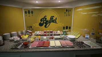 Una mesa de buffet con diversos alimentos y utensilios.