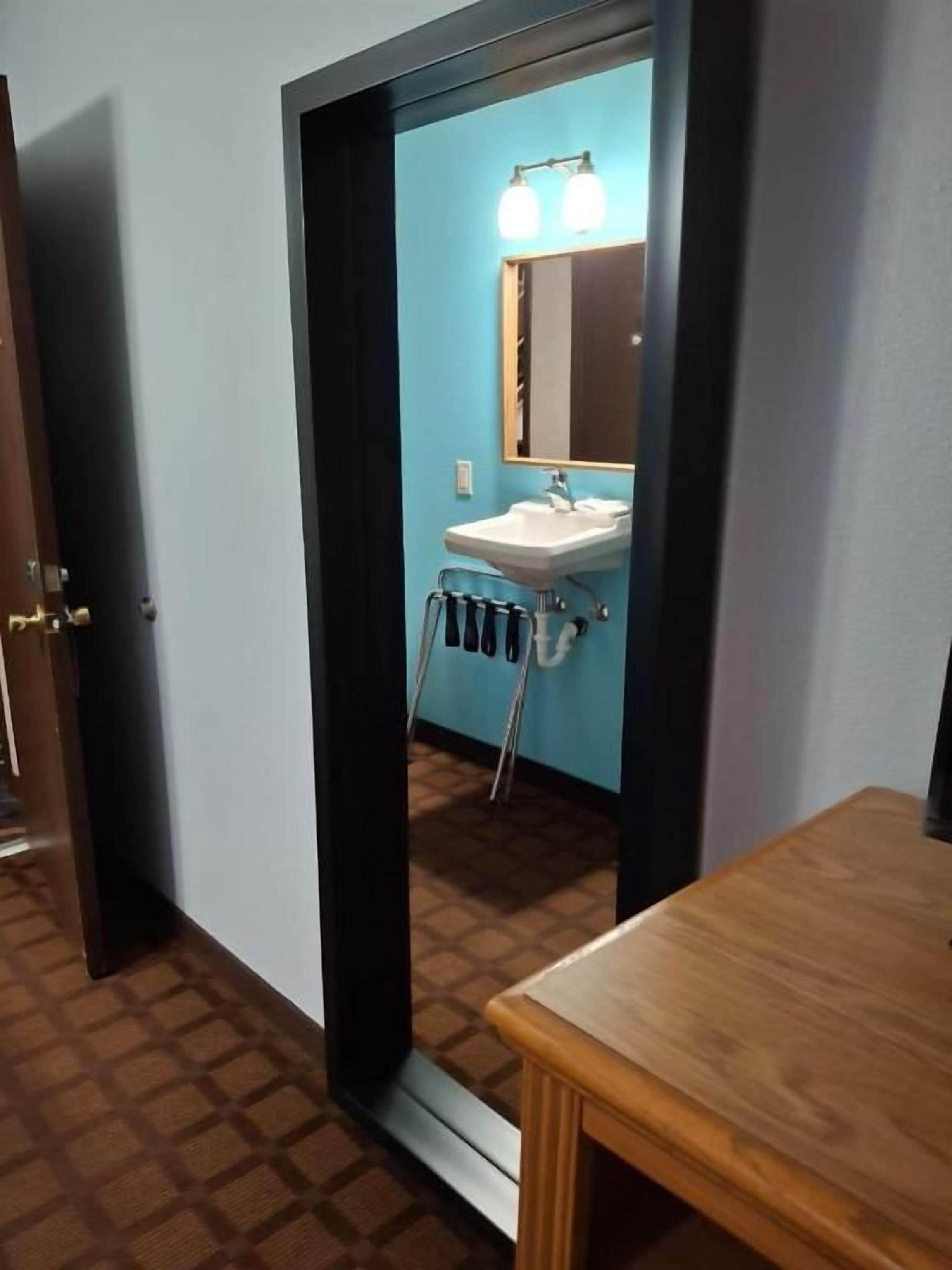 A bathroom with a sink, mirror, and towel rack.