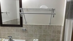 Une salle de bain avec un lavabo blanc, des toilettes et un miroir au-dessus du lavabo.