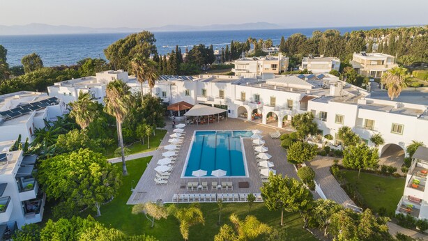 A resort with a central swimming pool, multiple guest rooms, and a view of the sea. - Alexandra Beach Hotel (Kos)