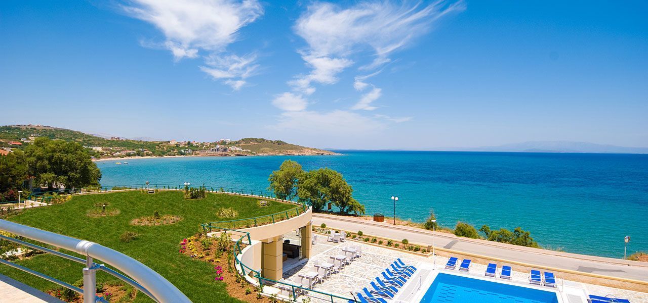 Zona de piscina con sillones de descanso y vista al mar.