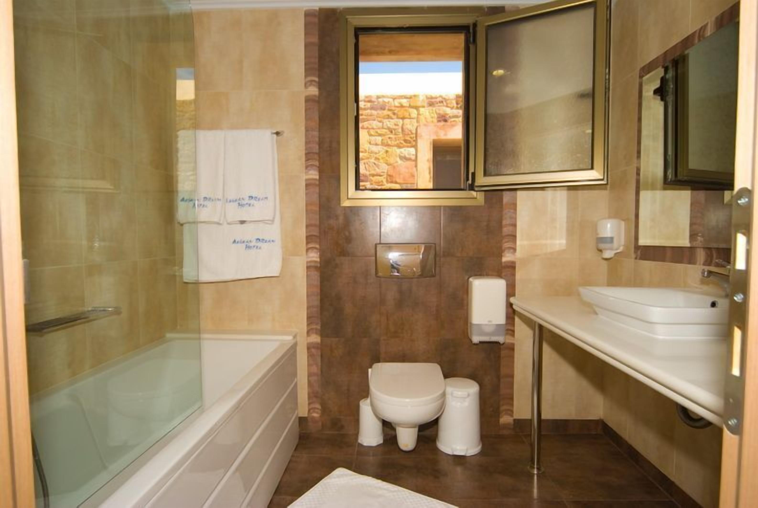 A bathroom with a glass-enclosed shower, a toilet, and a sink.