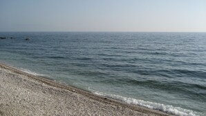 A beach with pebbles and calm water. - Kyveli Apartments (Chios)