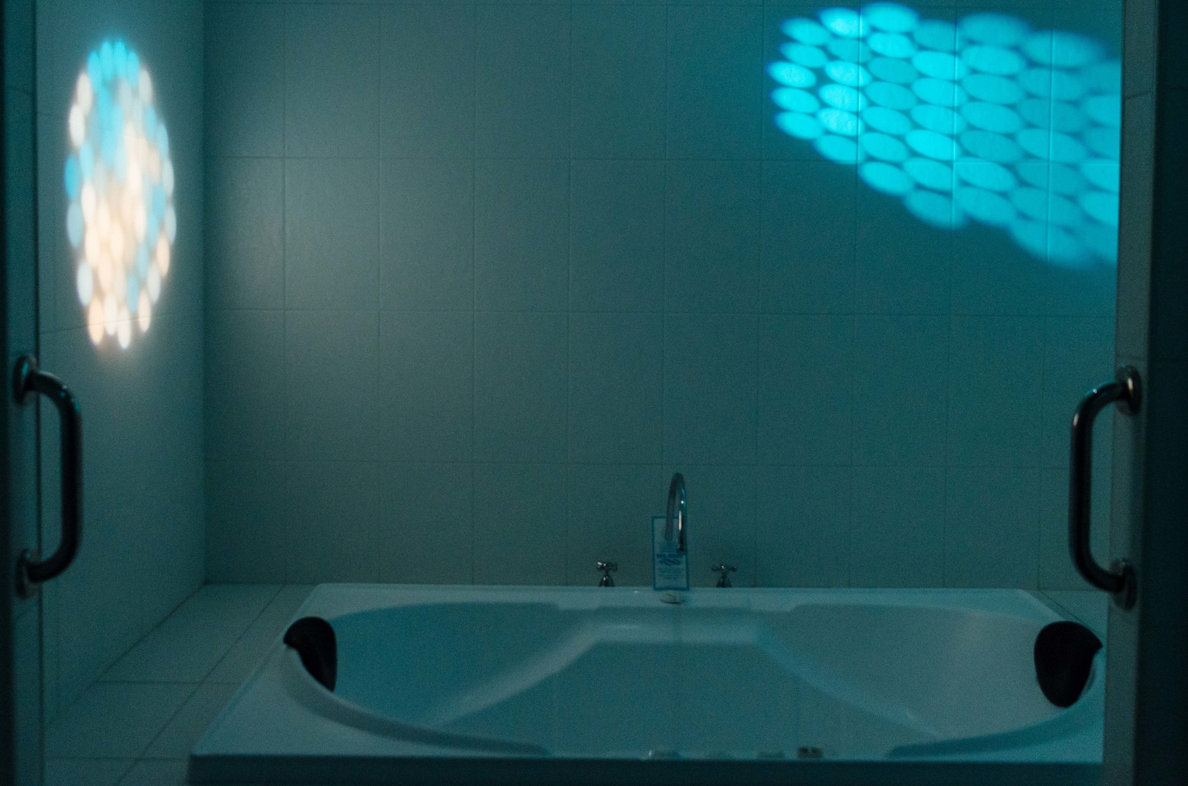 A bathroom with a bathtub, two faucets, and a showerhead.