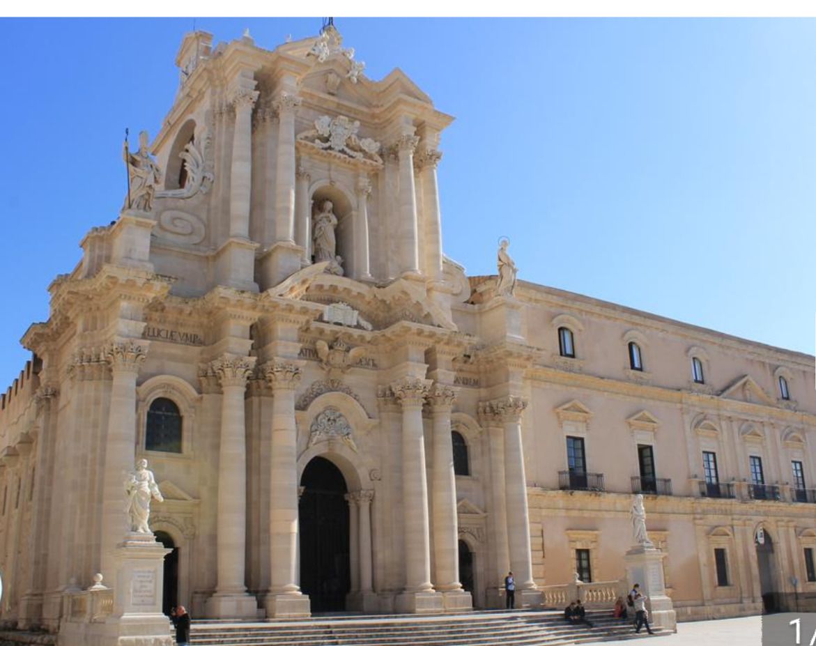 Un edificio grande y ornamentado de arquitectura clásica, con columnas, estatuas y elaborados relieves.