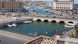 A marina with boats, a bridge, and buildings in the background.