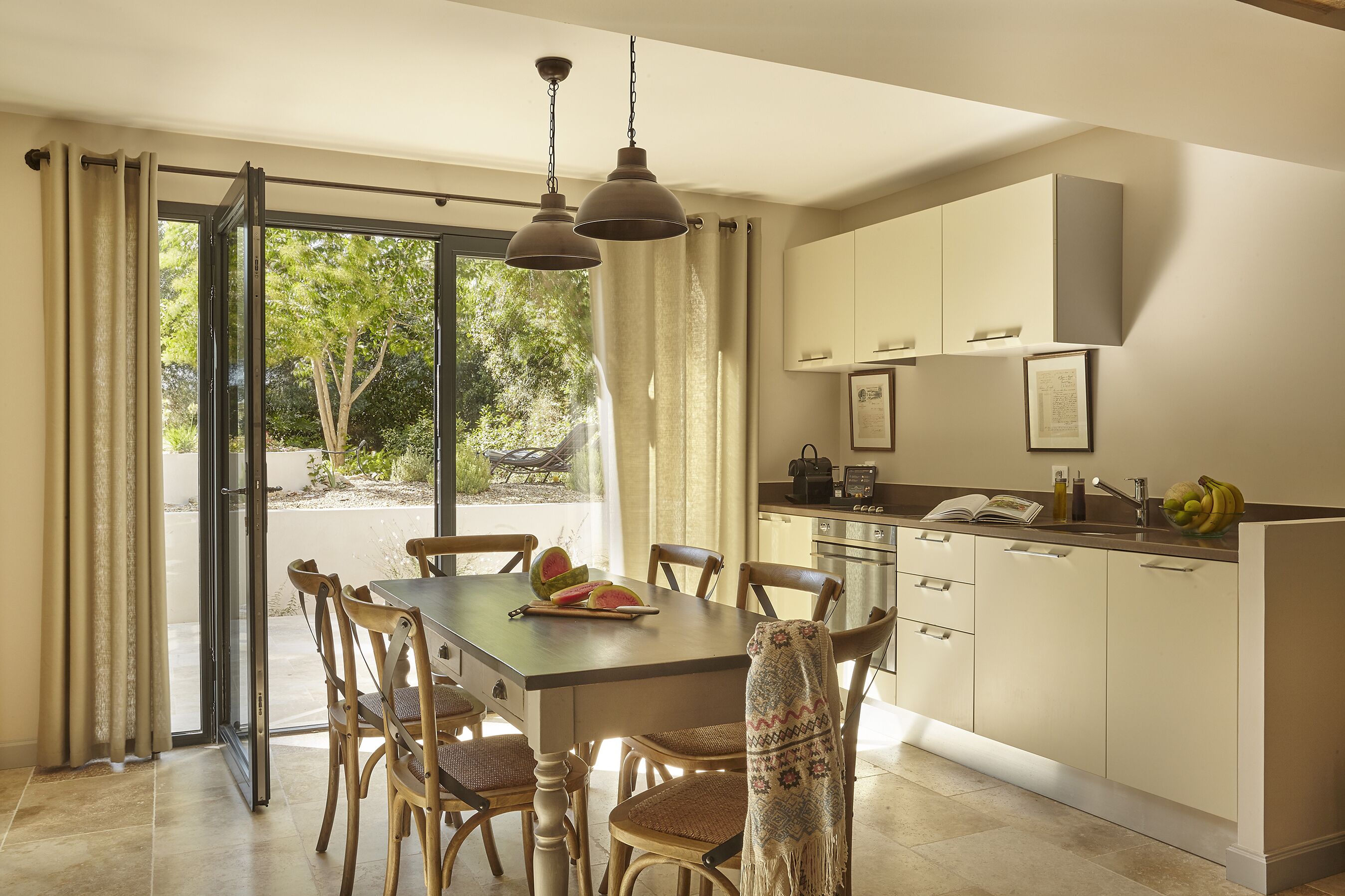 Una cocina moderna con comedor, ventanas amplias y vistas al exterior.