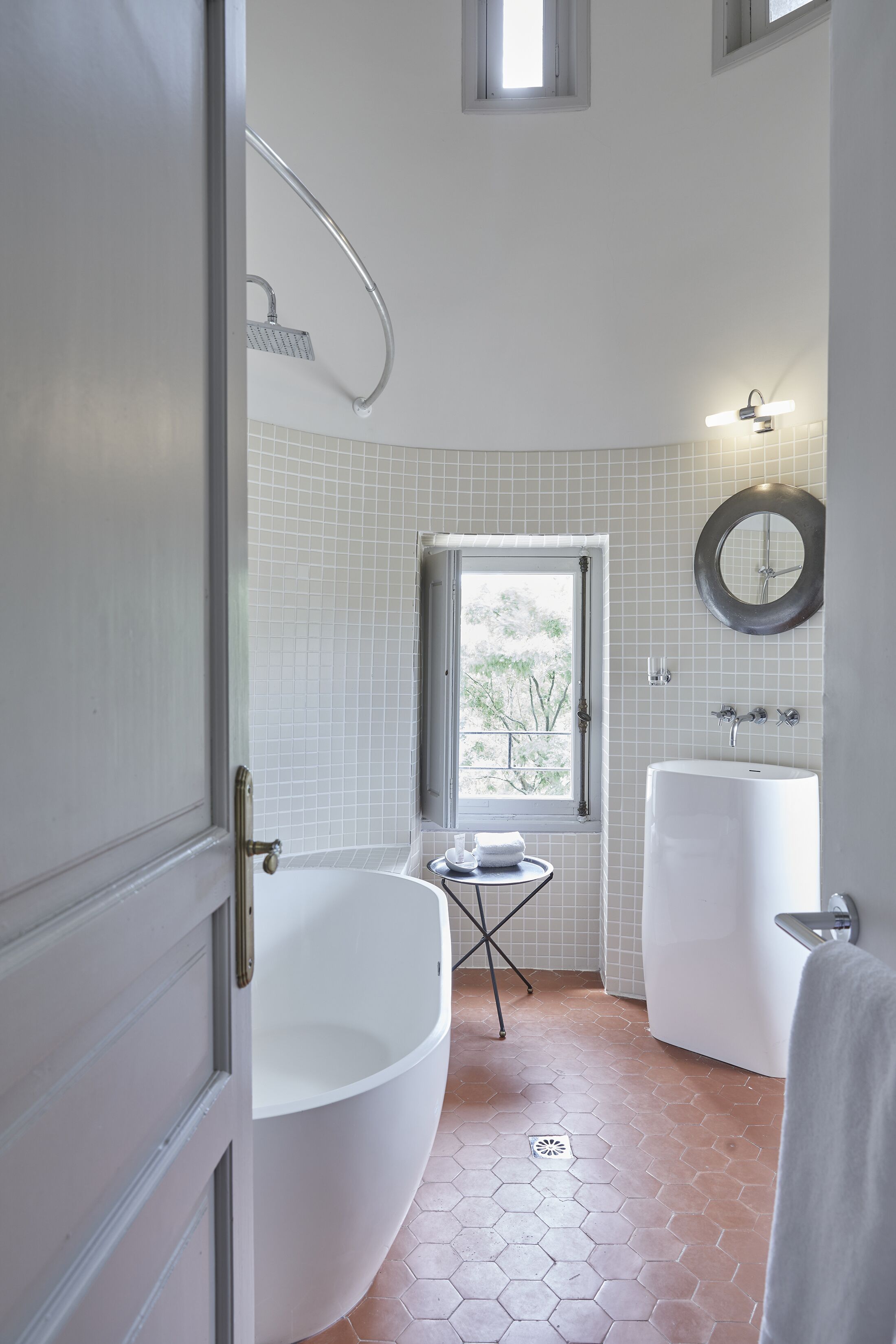 Un baño con una bañera grande, una ventana y un lavamanos.