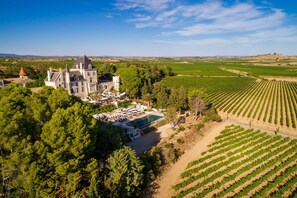 A large estate with a prominent building, a swimming pool, and expansive vineyard fields. - Château Les Carrasses (Quarante)