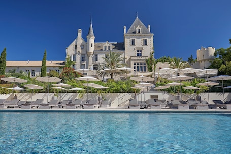 Una piscina al aire libre de temporada, sombrillas