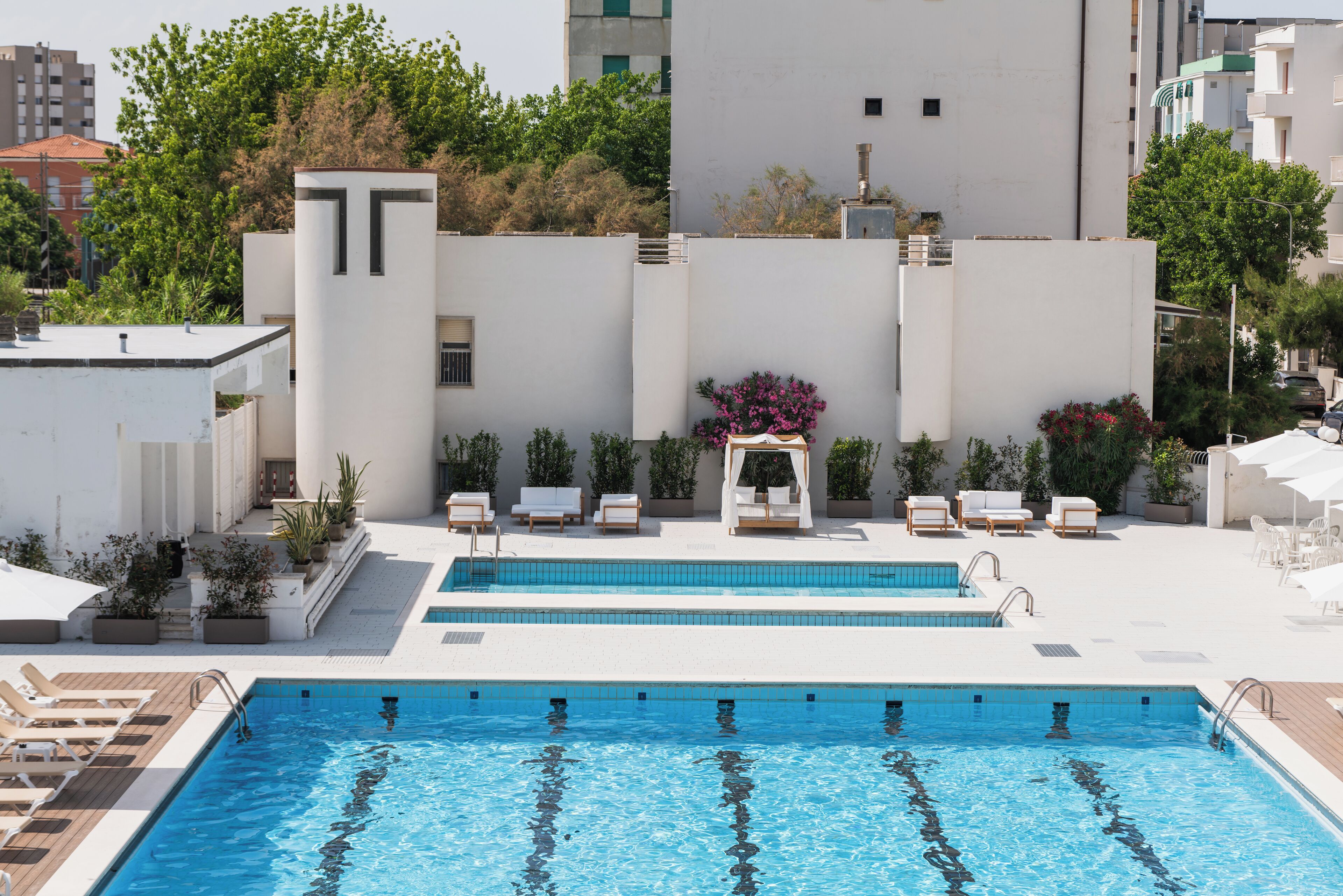 A rooftop swimming pool with lounge chairs and a small garden area.