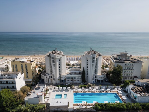 A resort with a large pool, beach access, and multiple high-rise buildings.