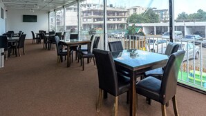 A conference room with a large table and chairs, a whiteboard, and a view of a parking area through large windows. - Coral Eforie Nord (Eforie)