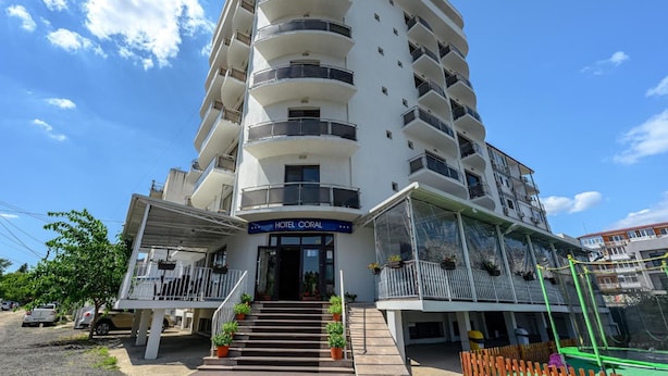 A multi-story hotel with a central entrance, balconies on each floor, and a clear sky. - Coral Eforie Nord (Eforie)
