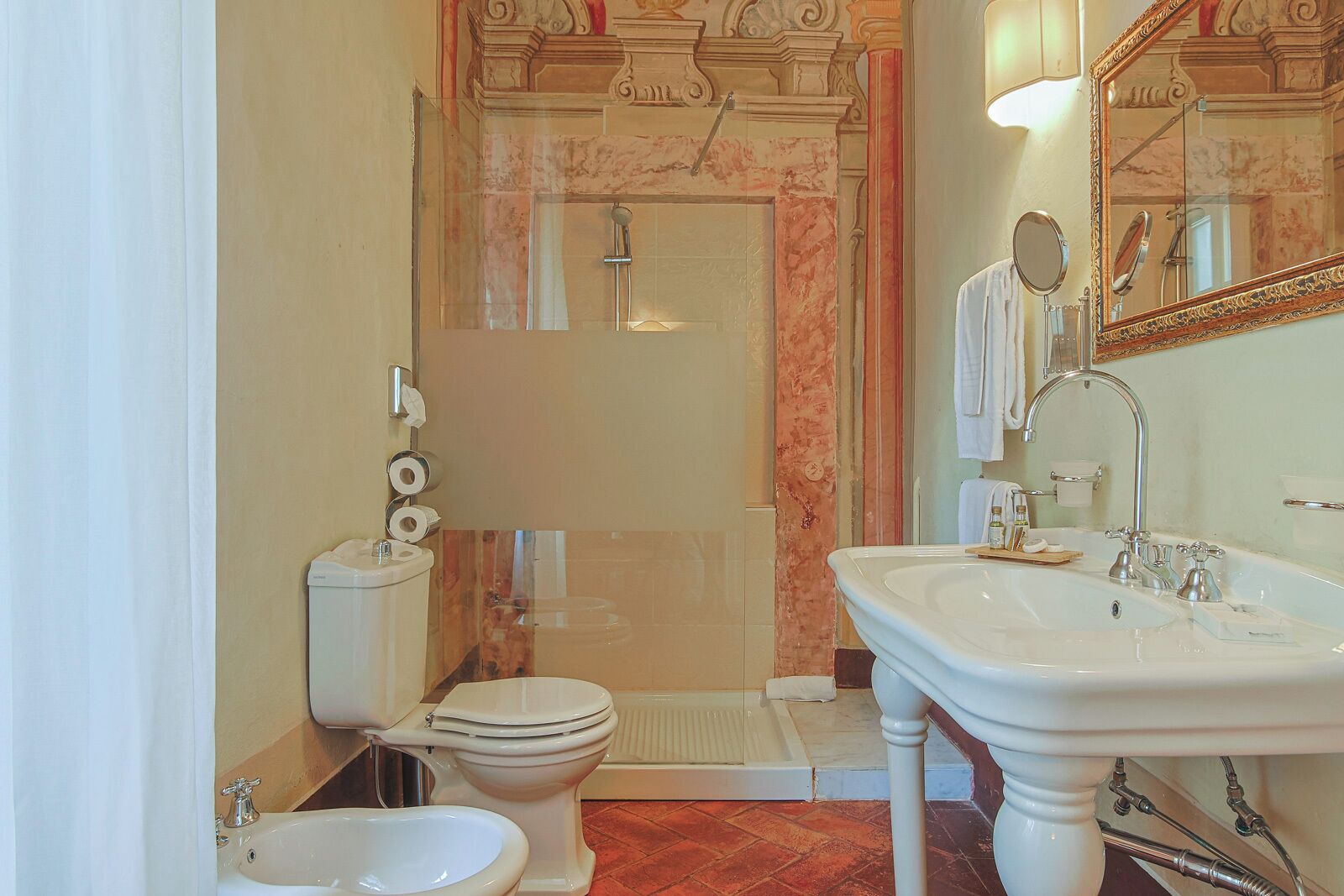 Une salle de bain équipée de toilettes, d’un bidet, d’un lavabo et d’une douche.