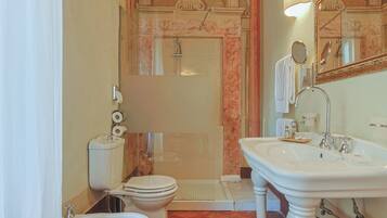 Une salle de bain équipée de toilettes, d’un bidet, d’un lavabo et d’une douche.