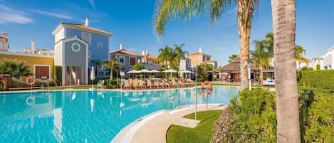 Una piscina al aire libre de temporada, sombrillas, tumbonas