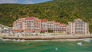 A beachfront hotel with multiple balconies, a pool area, and a view of the ocean. - Royal Bay Hotel – All Inclusive (Elenite)