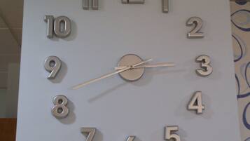 A wall clock with a minimalist design, featuring numbers 1 through 12 and a second hand.