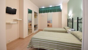 Un dormitorio con dos camas, televisión, armario y baño.