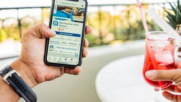 A person holding a smartphone displaying a hotel booking page for the Morning Star Hotel in Greece.
