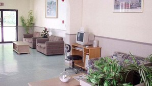 A lobby with seating, a reception desk, a computer, and a plant. - Tamuning Plaza Hotel (Tamuning)