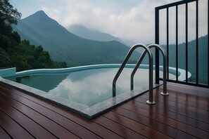 Una piscina al aire libre, sombrillas, sillones reclinables de piscina