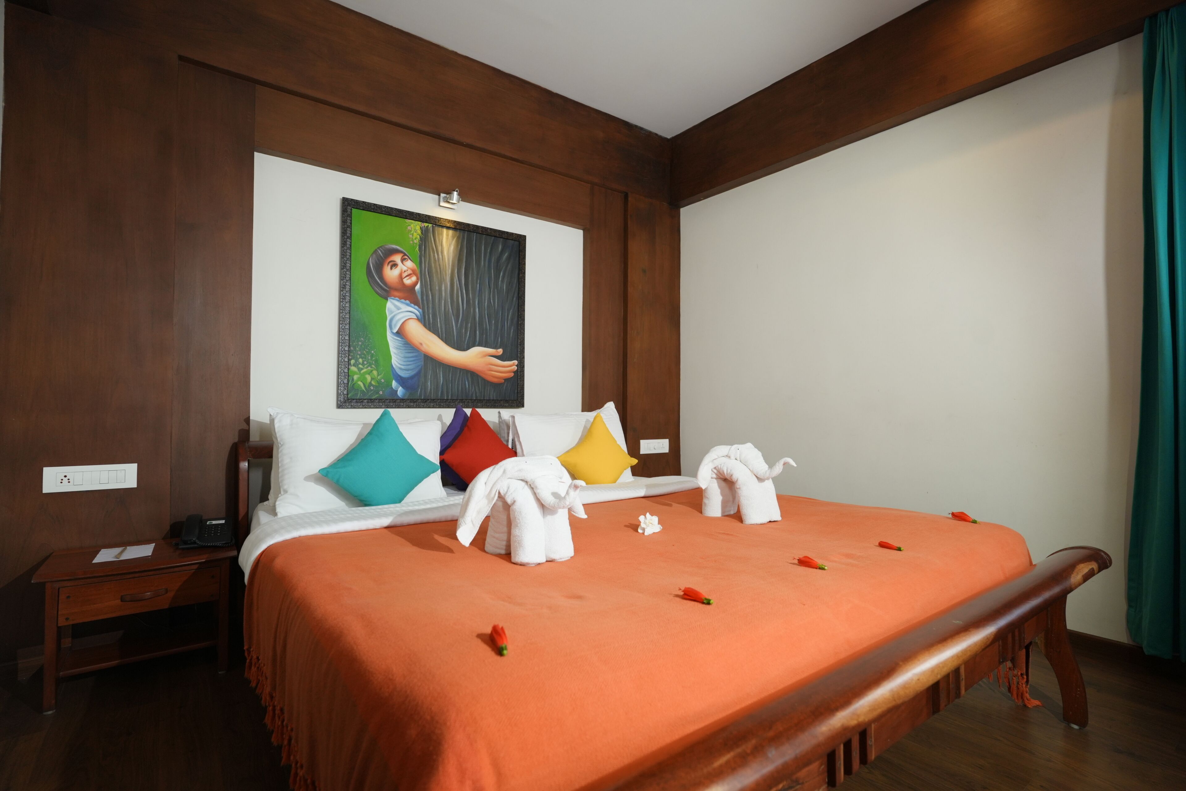 Ein Hotelzimmer mit einem Bettgestell aus Holz, einer orangefarbenen Bettdecke und einem Gemälde an der Wand.