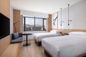 A hotel room with two beds, a sofa, a small table, a TV, and a large window with a city view. - Fairfield by Marriott Hangzhou Xihu District (Hangzhou)