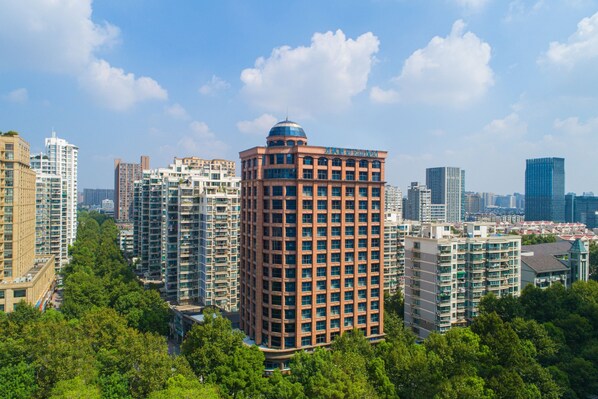 A high-rise building with a dome on top, surrounded by other tall buildings and greenery. - Fairfield by Marriott Hangzhou Xihu District (Hangzhou)