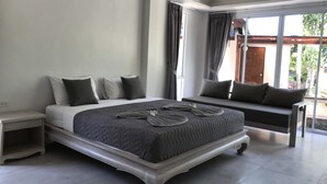 A bedroom with a large bed, a bench, and a window with curtains. - Phalarn Inn Resort (Koh Samui)
