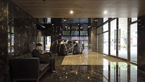 A modern lobby with a marble floor, a seating area, and a large window offering a view of the street. - Gloria Residence (Taipei)